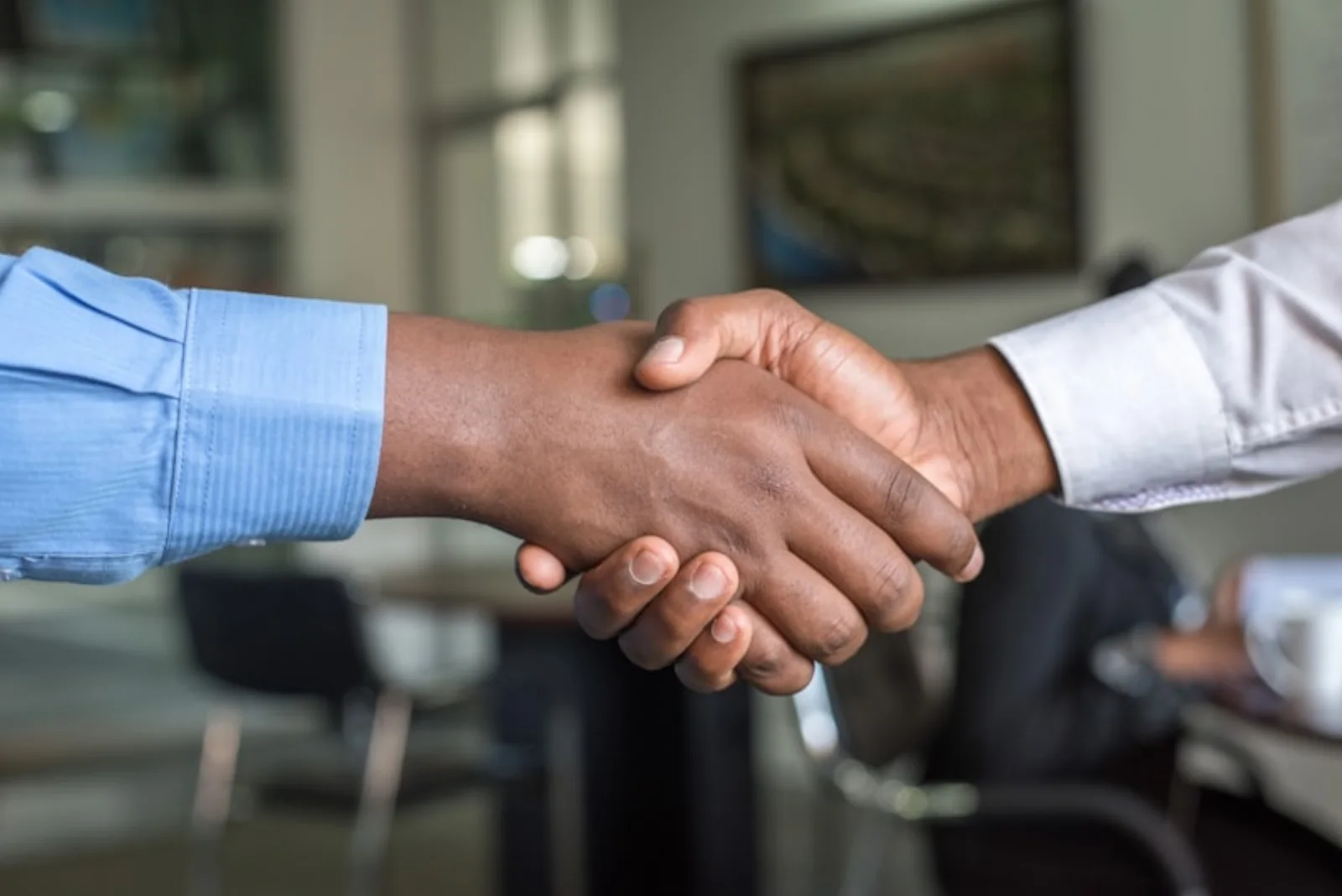 Twee mensen geven elkaar een hand in een kantoor