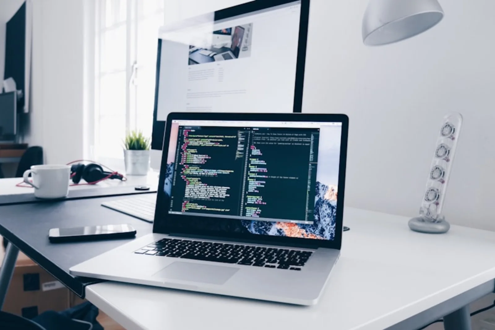 Een opgeruimd bureau met laptop en tweede scherm